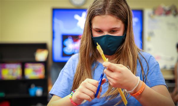 Girl cuts tape on spaghetti tower